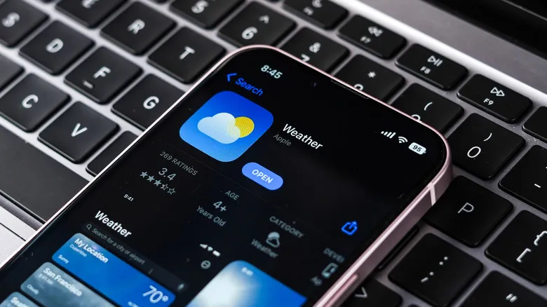 The iPhone Weather app as shown in App Store, displayed on an iPhone resting on a computer keyboard