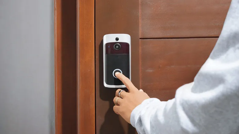 A person interacting with an unspecified video doorbell device.