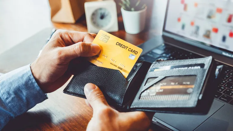 Hand putting credit card inside wallet