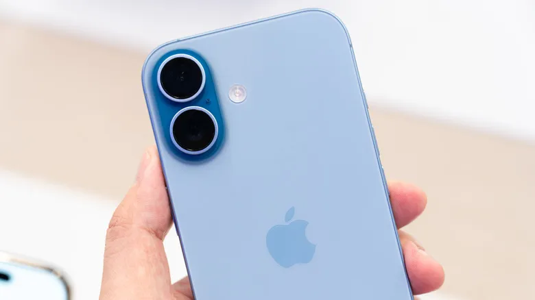 Close up of a hand holding the iPhone 17 in Mist Blue in a store