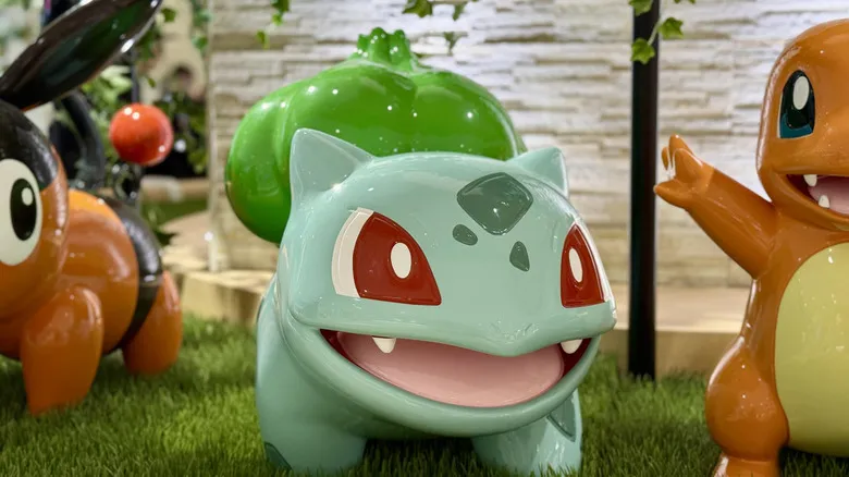 Bulbasaur, Charmander, Tepig statue in a synthetic wild grass setting at a store