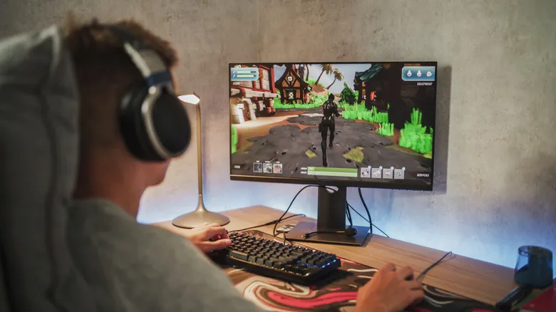 Person playing a PC game with keyboard and mouse on desktop monitor