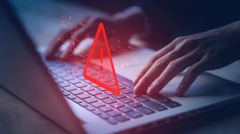 A scam warning graphic over an image of a person on a laptop