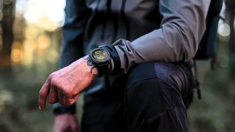 A man's wrist showing a Garmin watch