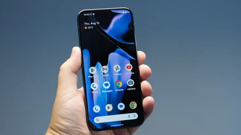 Person holding up a Pixel 9 phone showing the home screen