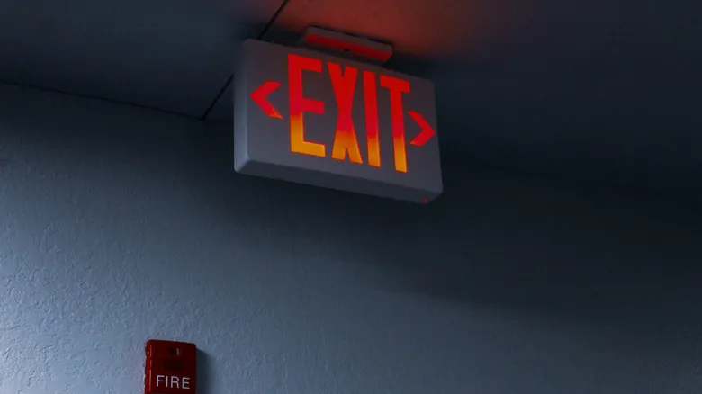 An illuminated exit sign in a hallway.