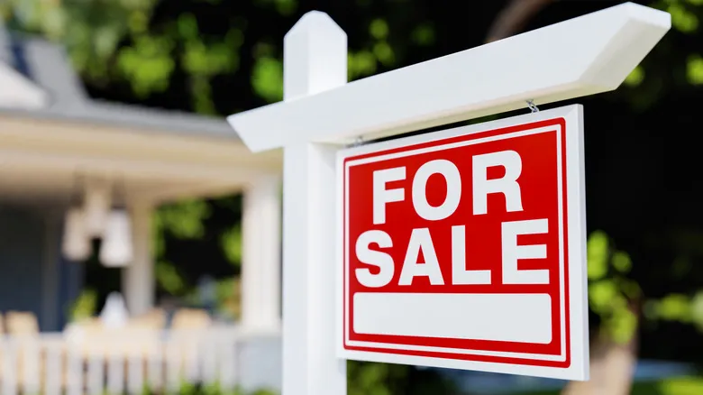 A real estate for-sale sign outside of a house