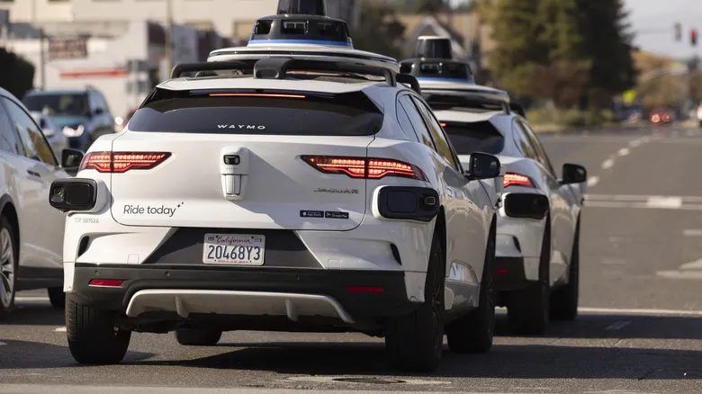 Two Waymo vehicles at a stoplight