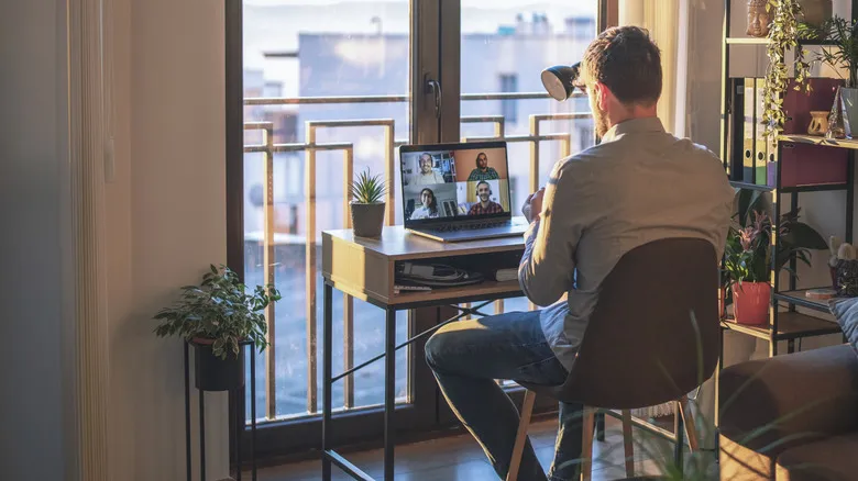 Remote worker using video conferencing app for meeting.