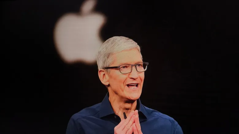 Apple CEO Tim Cook behind an Apple logo