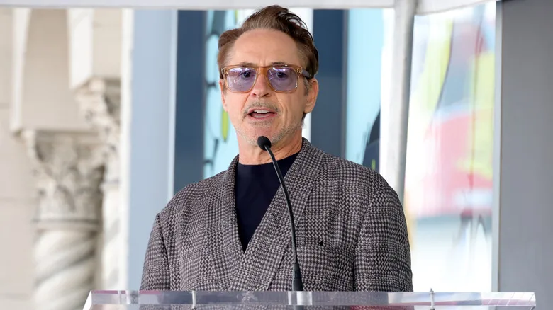Robert Downey Jr. on a podium in sunglasses and a suit