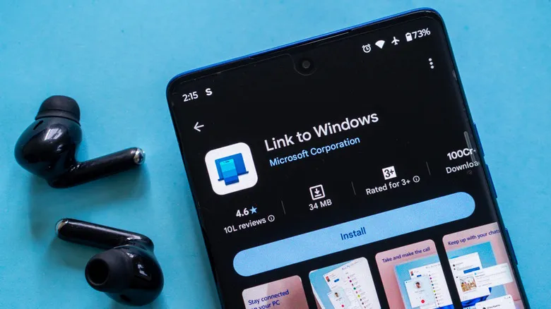 A pair of earbuds sitting next to a phone with the Link to Windows app open.