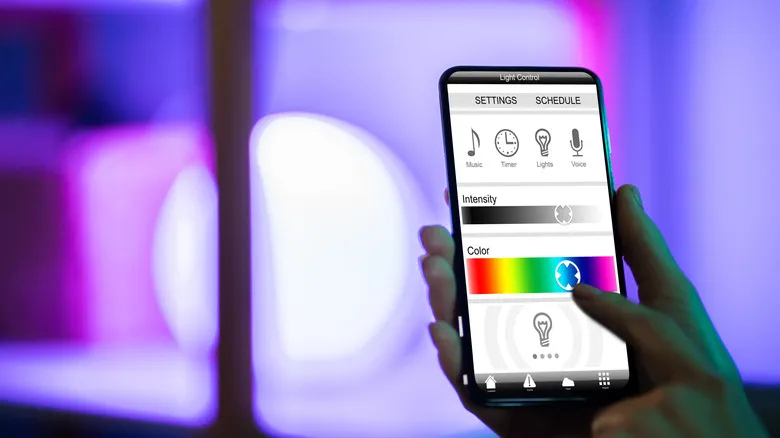 Person adjusting smart lighting color and brightness through mobile app