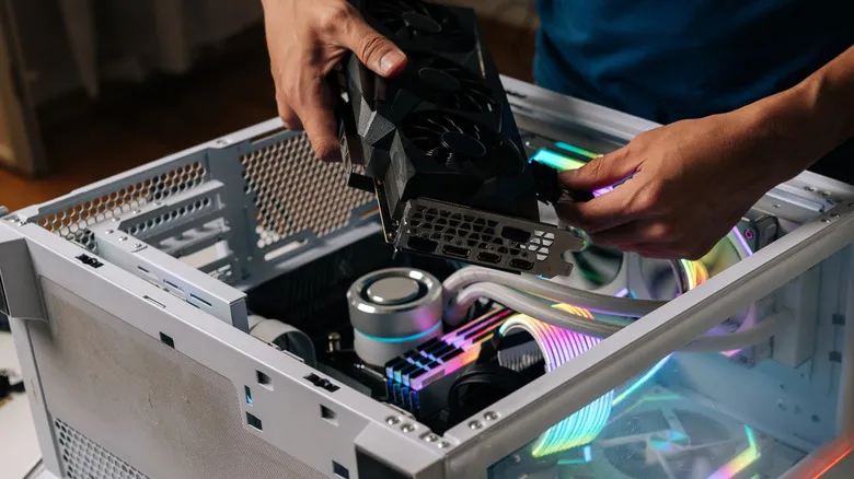 A man plugging in cables to his GPU and getting ready to install it into his PC