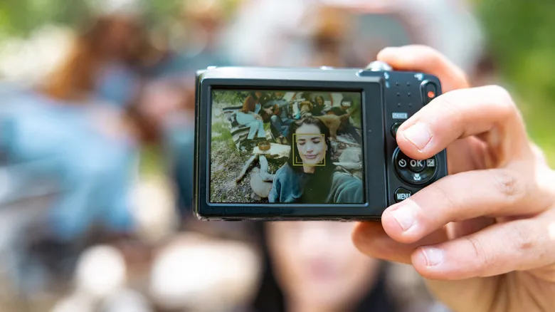Person taking selfie with retro digital camera